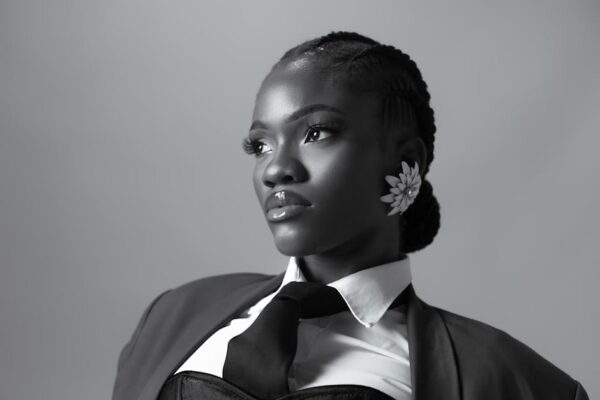 Striking portrait of a woman in black and white with bold earrings and professional attire.